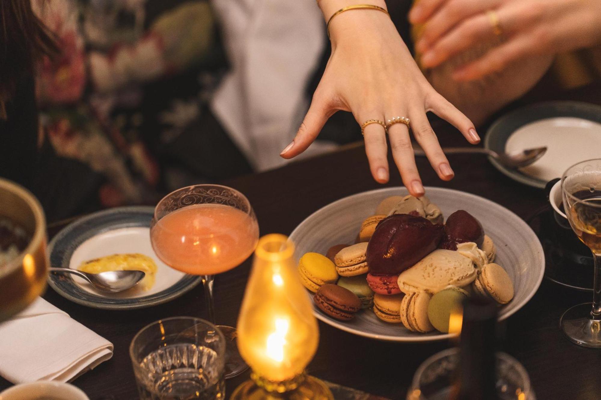 Hotel Pigalle Göteborg Kültér fotó A woman's hand reaches for a plate of macarons